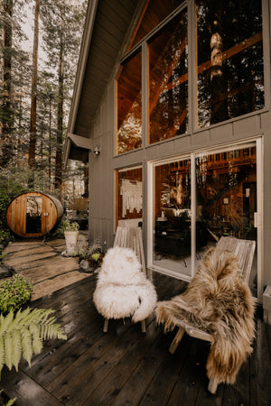 Hazel Icelandic Sheepskin on some chairs outside of a cabin in the woods